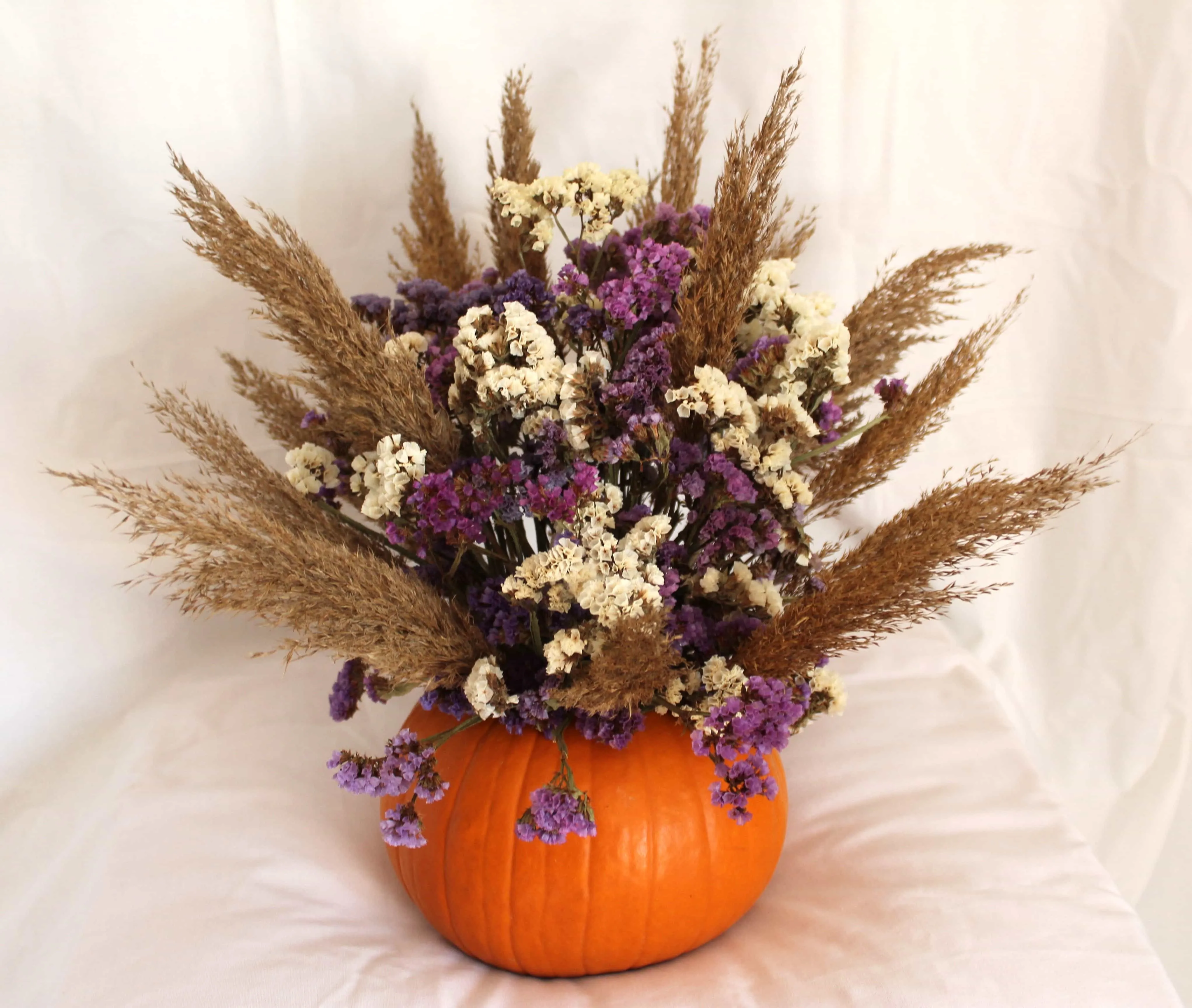 Arreglo floral de calabaza, statice y cañizo