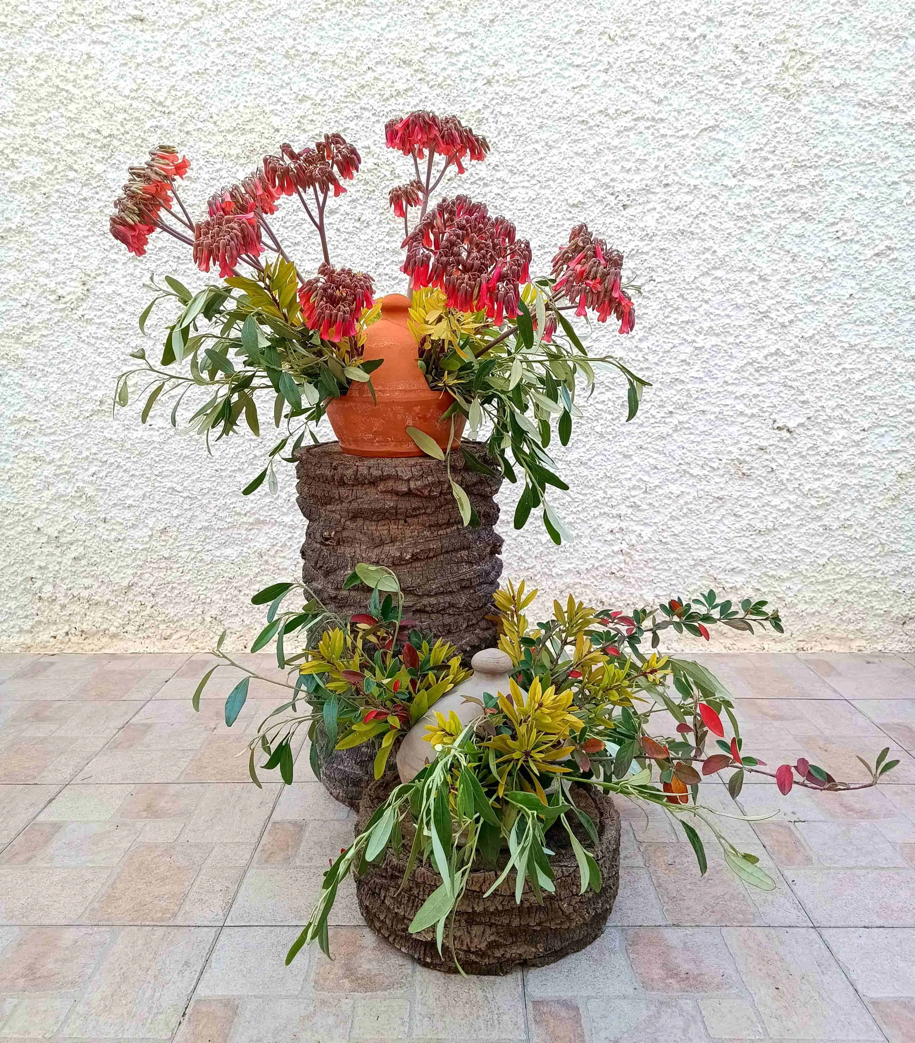 Arreglo floral en comederos de pájaros, sobre base de palmera