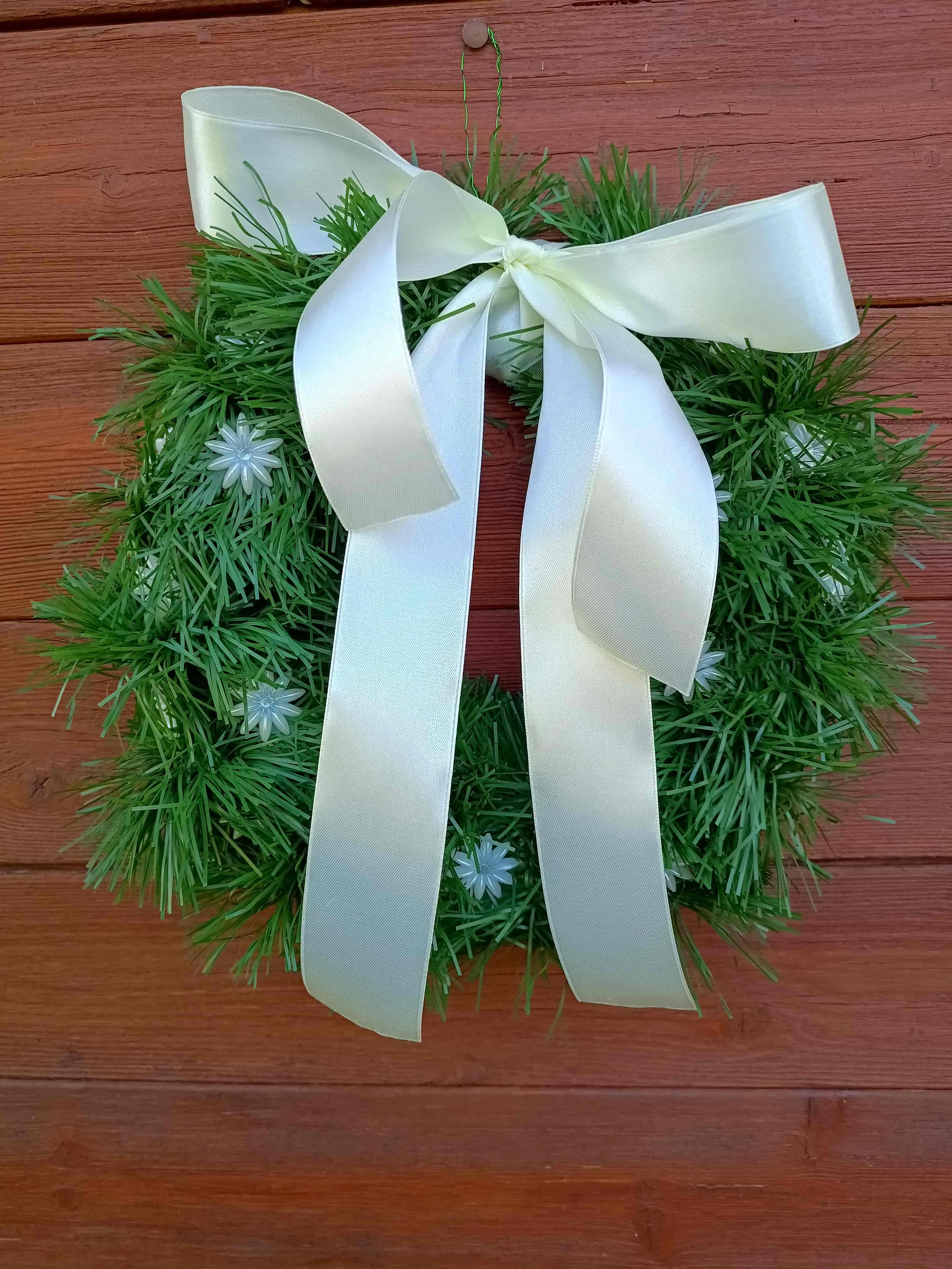 corona con espumillón y flores perla brillantes